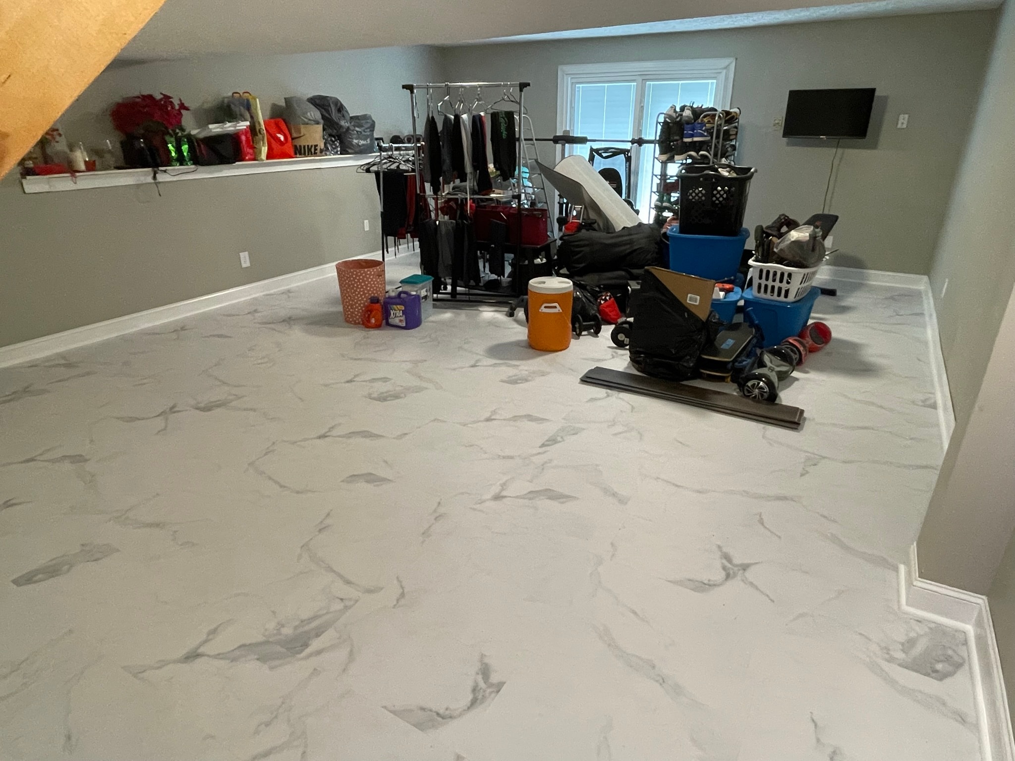 Basement after flooring installation — beautiful marble-look luxury vinyl plank flooring