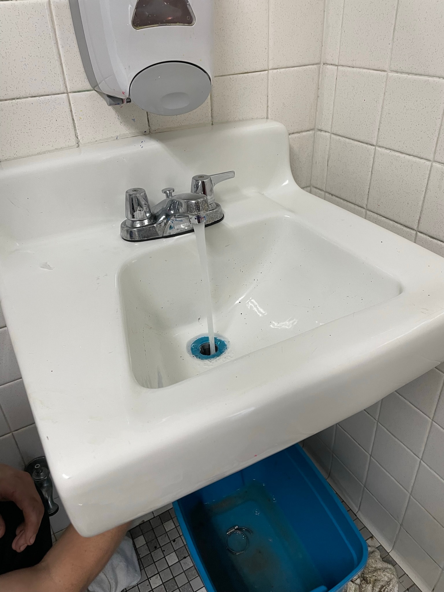 Bathroom sink after repair — clean basin with water flowing freely down drain