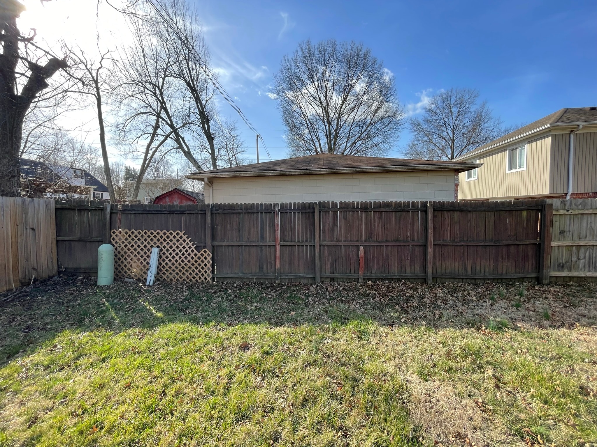 Backyard fence before replacement — dark weathered and rotting wood fence panels along property line