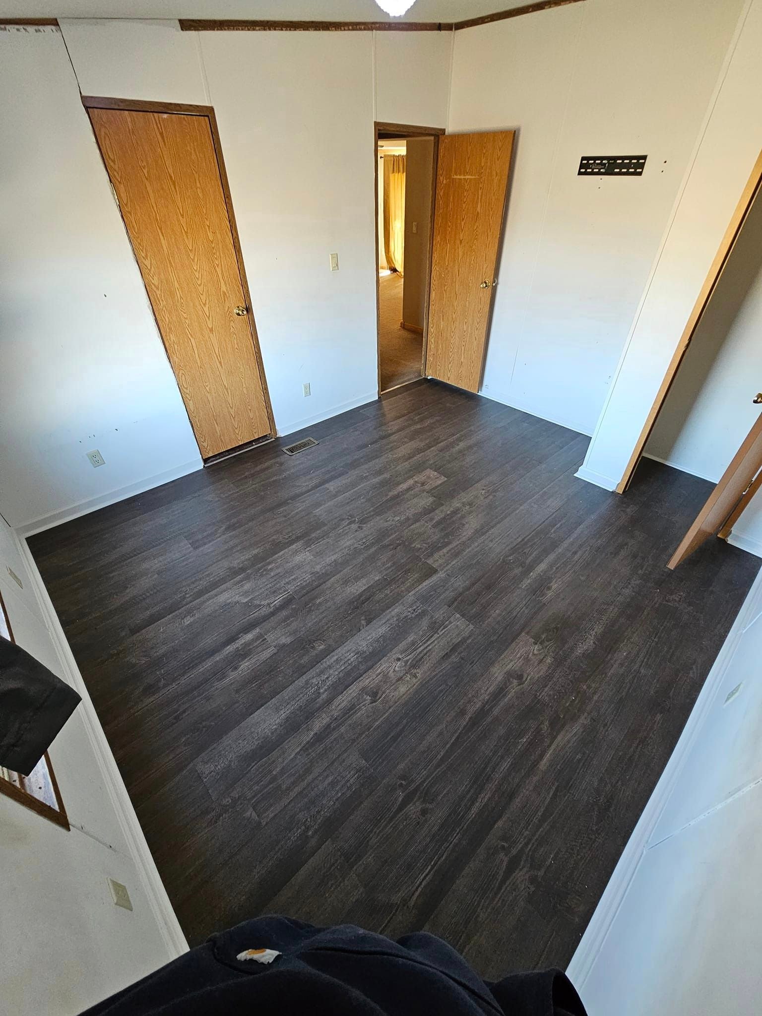 Bedroom after flooring renovation — new dark charcoal luxury vinyl plank flooring installed throughout