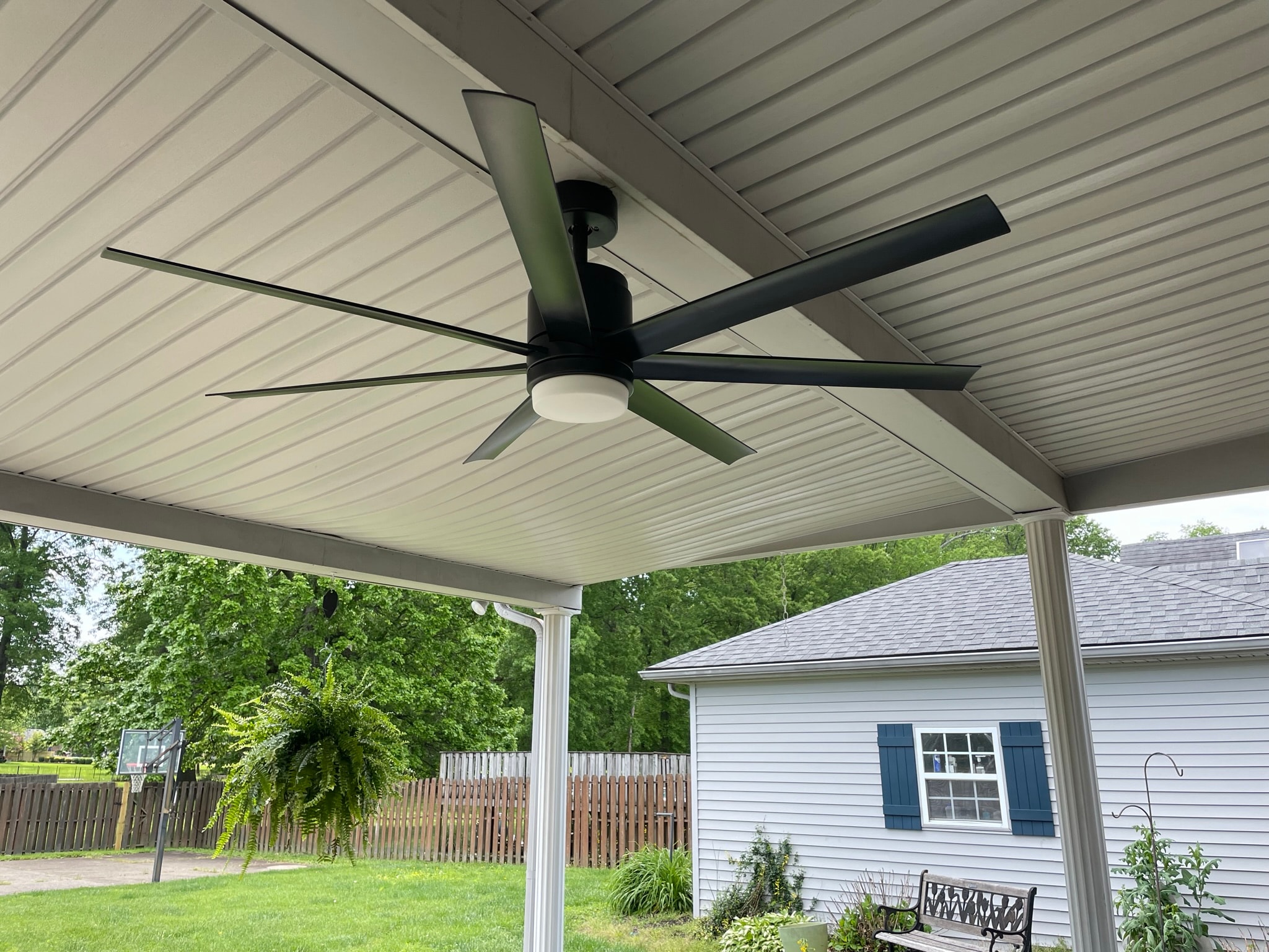 Patio ceiling after fan replacement — new modern 6-blade matte black outdoor ceiling fan with integrated light kit
