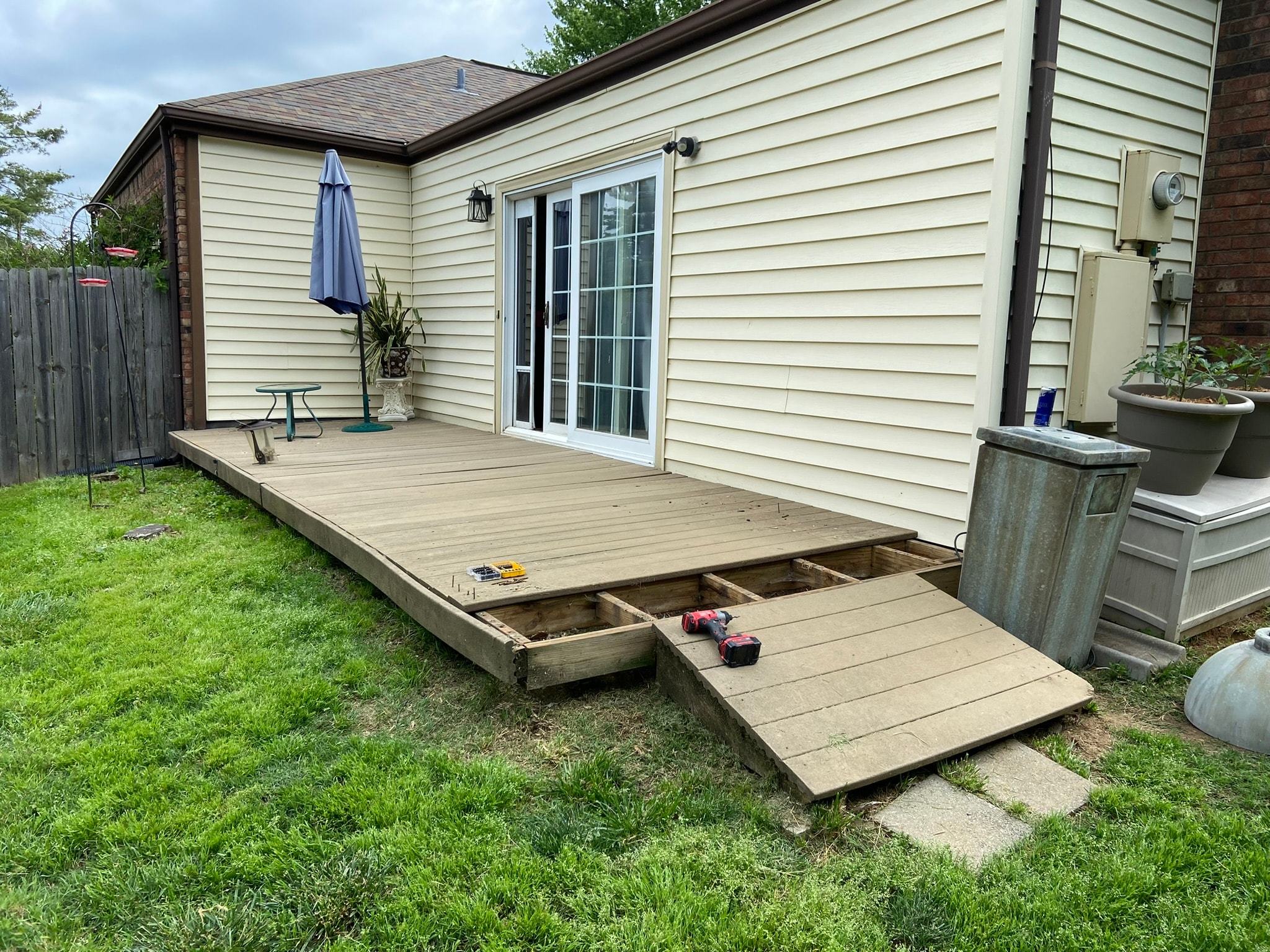 Backyard deck before renovation — worn boards with exposed framing and missing sections