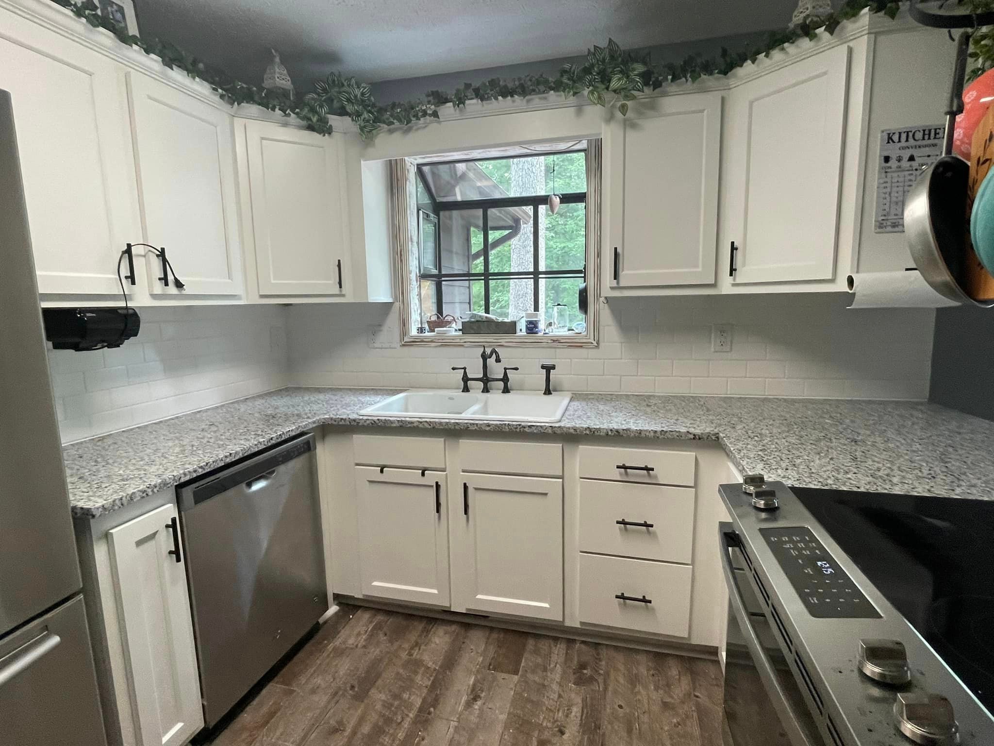 Kitchen after renovation — stunning granite countertops with white subway tile backsplash