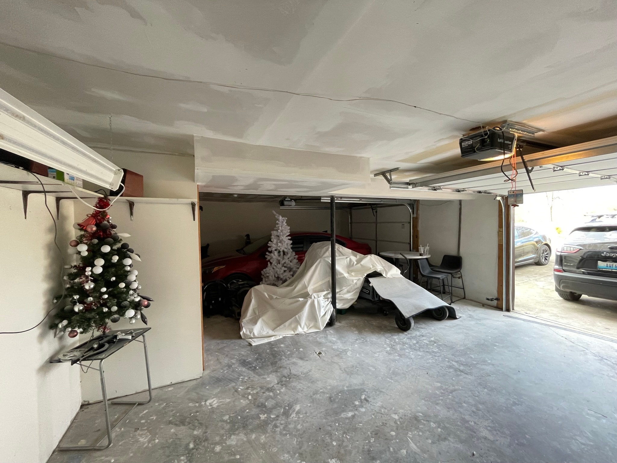 Garage ceiling after drywall installation — smooth finished ceiling with garage door opener