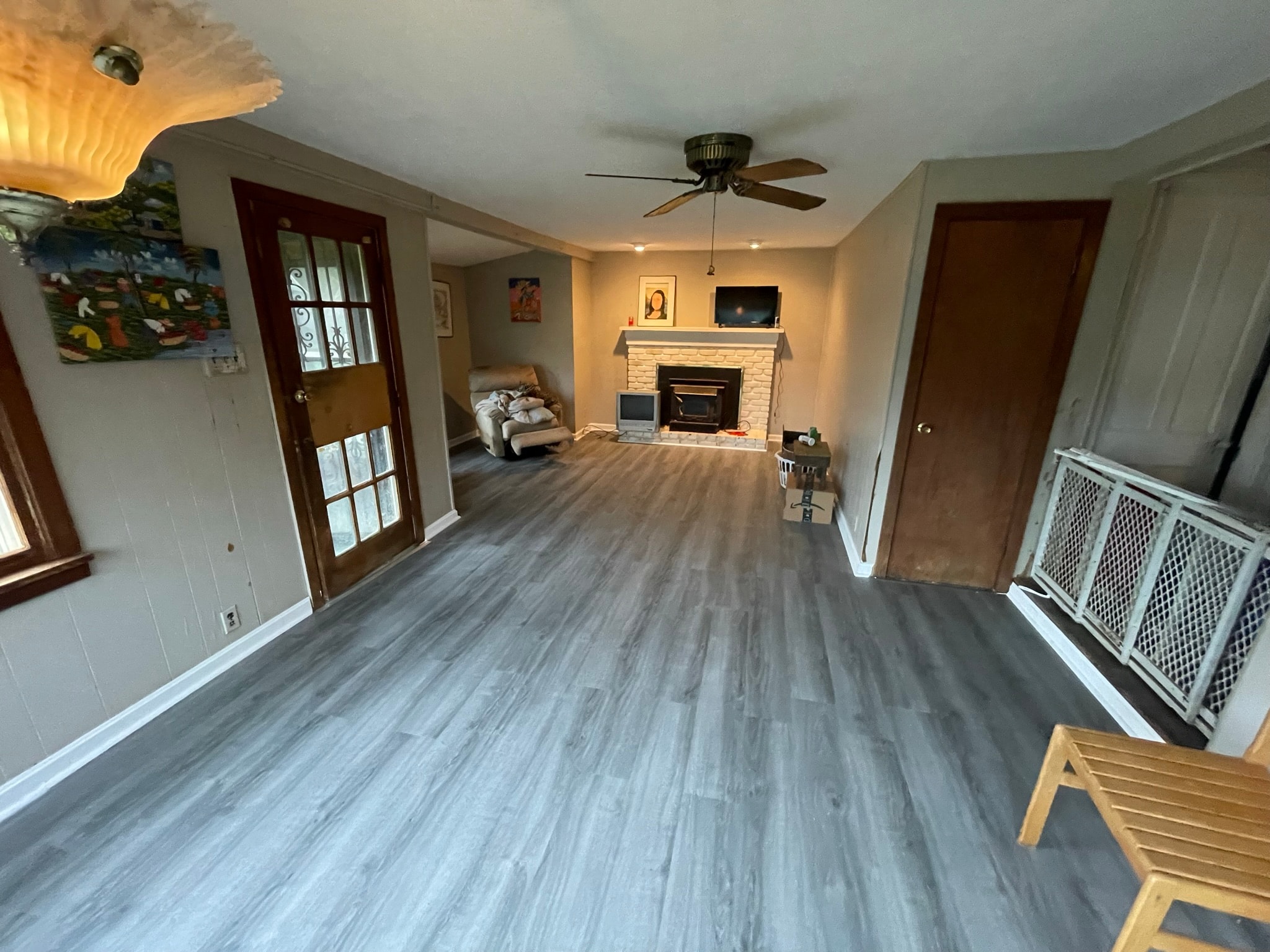 Living room after flooring — stunning grey luxury vinyl plank with fireplace